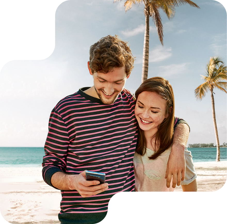 Frau und Mann genießen die Vorteile der Travel Mobil Optionen am Strand