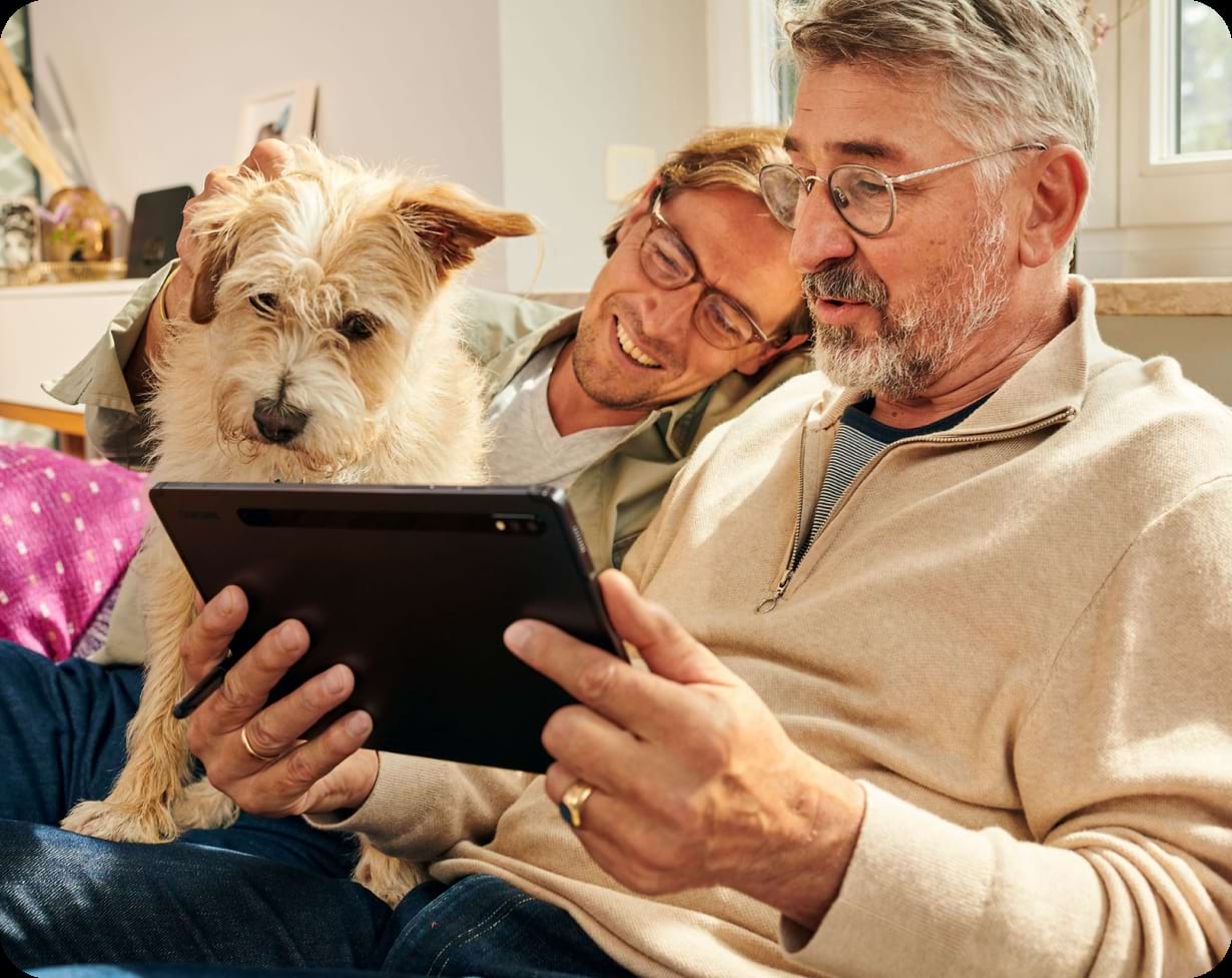 Zwei Männer auf einem Sofa die ganz einfach ihren Internet- und Fstnetztarif, über die Telekom, wechseln.