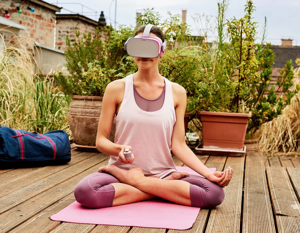 Frau mit VR-Brille auf einer Yoga-Matte als Symbolbild für die Zukunftssicherheit und Energieeffizienz von Glasfaser
