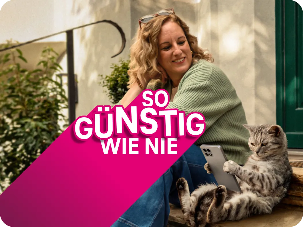 Frau sitzt lächelnd mit Katze auf einer Treppe und die Katze nutzt ihr Smartphone