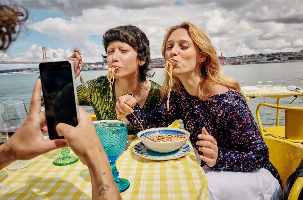 Zwei Freundinnen werden beim Pasta essen fotografiert