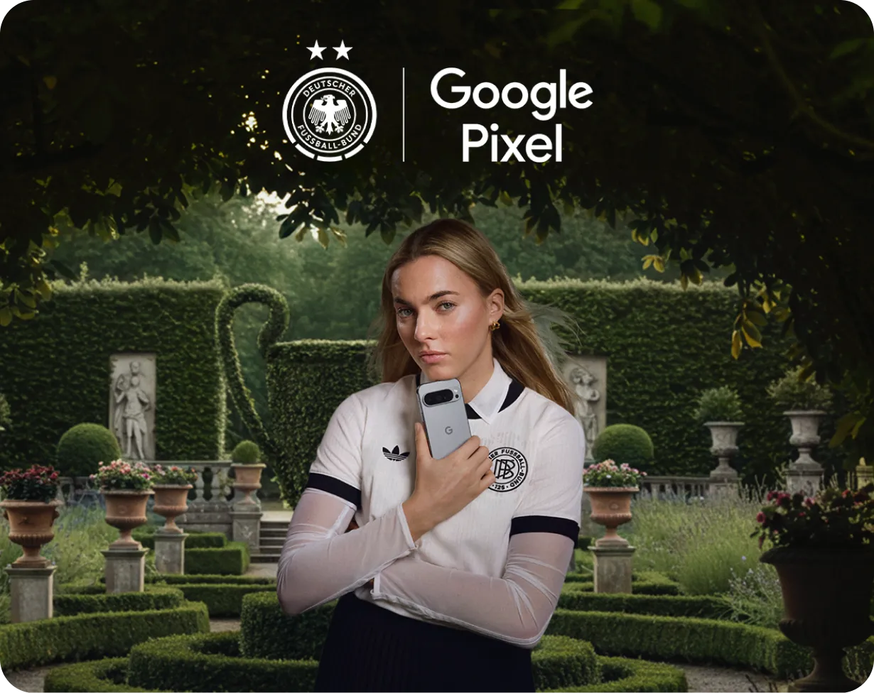 Elegante Präsentation des Google Pixel Smartphones durch DFB-Teammitglied in stilvollem Schlossgarten