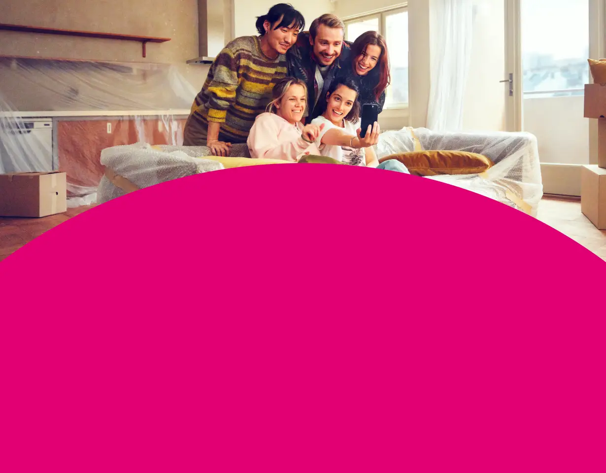 Freunde beim Selfie-Moment zwischen verpackten Möbeln im neuen Zuhause