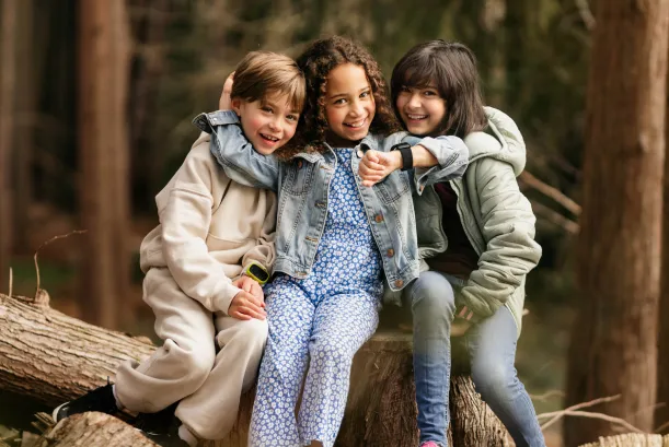 Zwei Kinder sind in der Natur. Eines der Kinder trägt die Kids Watch XPLORA X6 am Handgelenk. Beide Kinder schauen sich die Uhr an.
