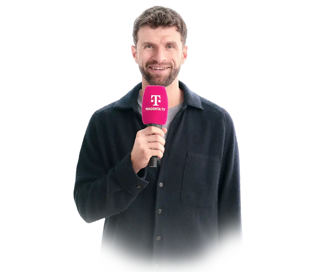 Top-Experte Thomas Müller hält ein Mikrofon mit Telekom-Logo und der Aufschrift MagentaTV in der Hand