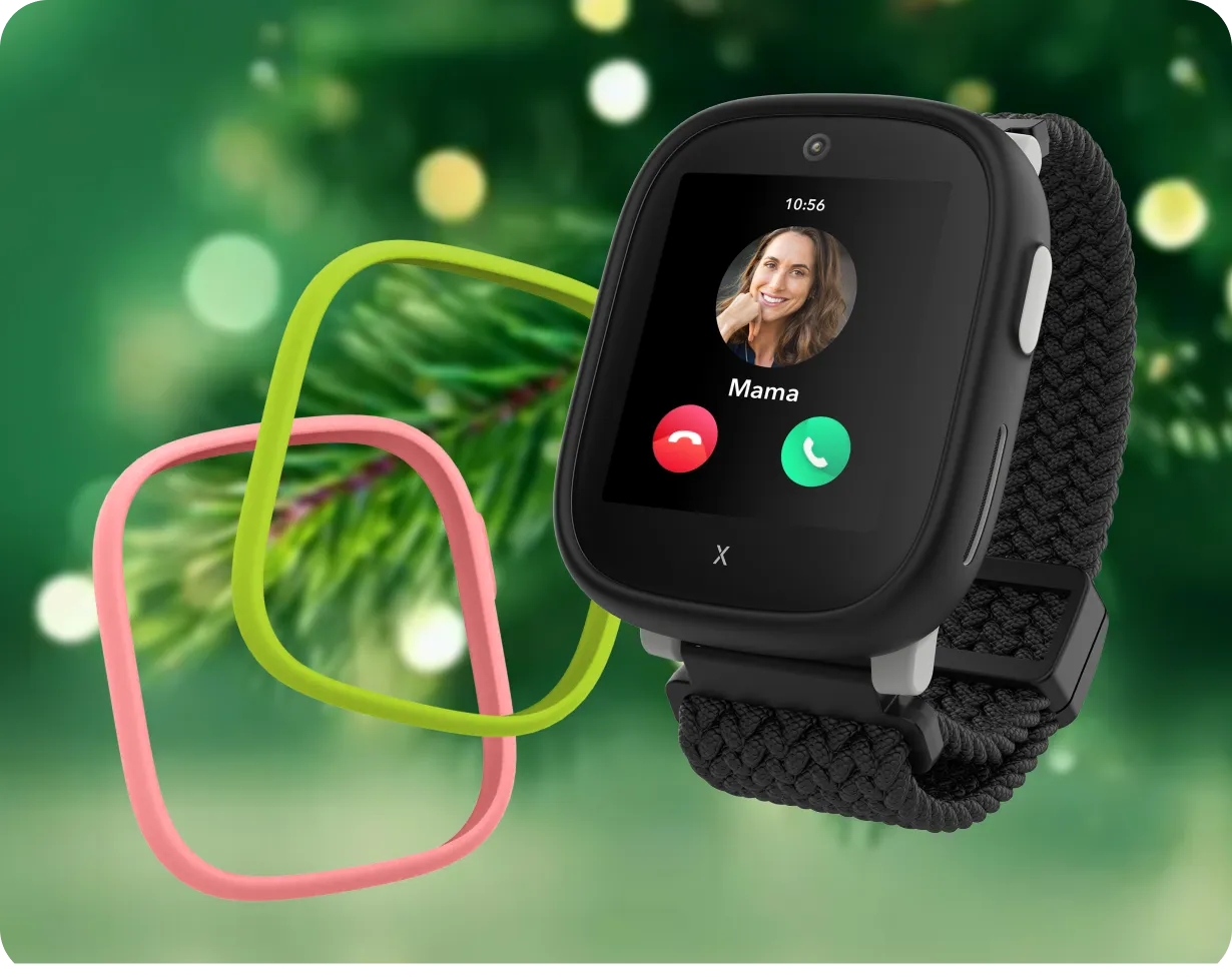 Schwarze XPLORA Kidswatch mit Geflechtsarmband zeigt einen eingehenden Anruf (Kontakt Papa); daneben zwei austauschbare Rahmen in Pink und Neongrün.