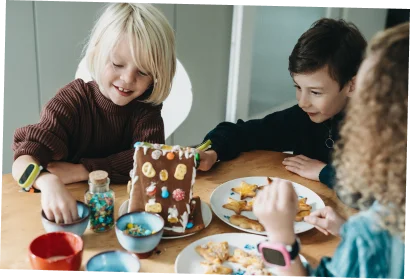 Kleiner Junge und kleines Mädchen, die auf einer Bank sitzen und sich gemeinsam die XPLORA X6 Play am Handgelenk des Jungen anschauen.