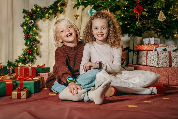 Zwei Kinder sind in der Natur. Eines der Kinder trägt die Kids Watch XPLORA X6 am Handgelenk. Beide Kinder schauen sich die Uhr an.