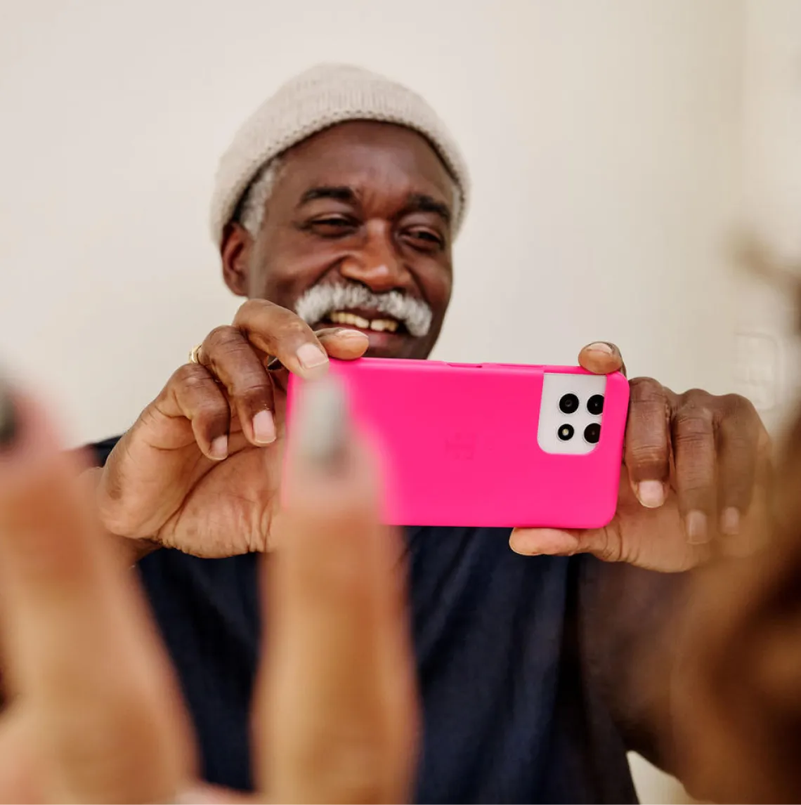 Person fotografiert eine Familie im Garten mit einem gebrauchten Handy