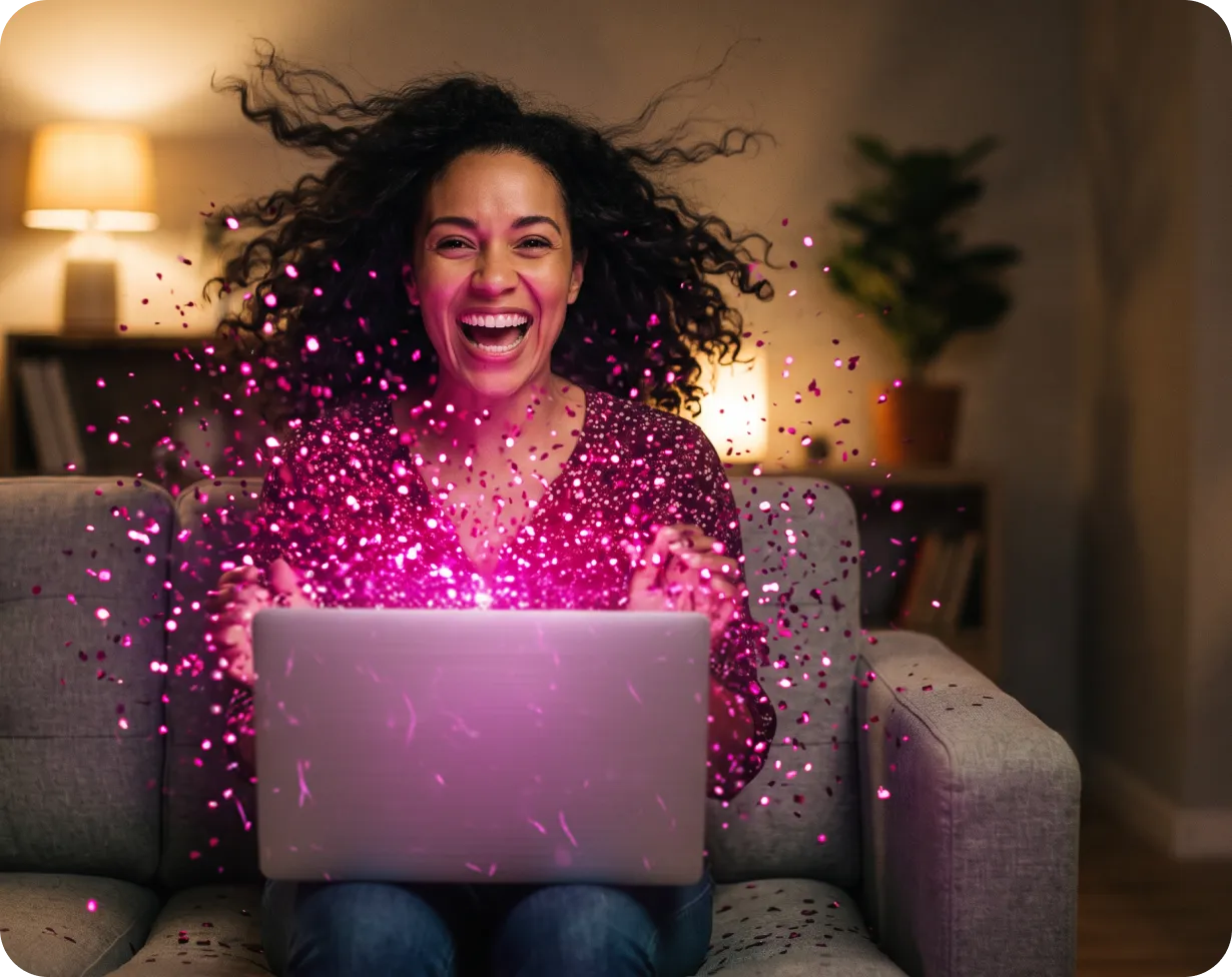 Lachende Frau mit Laptop auf dem Sofa, umgeben von magentafarbenem Konfetti