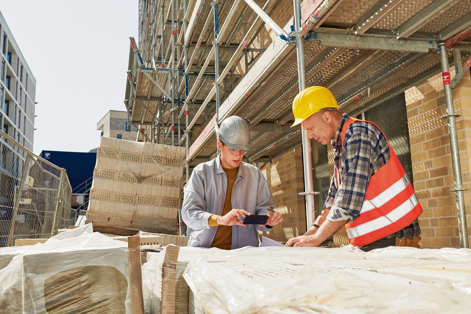 2 Menschen planen gemeinsam auf der Baustelle
