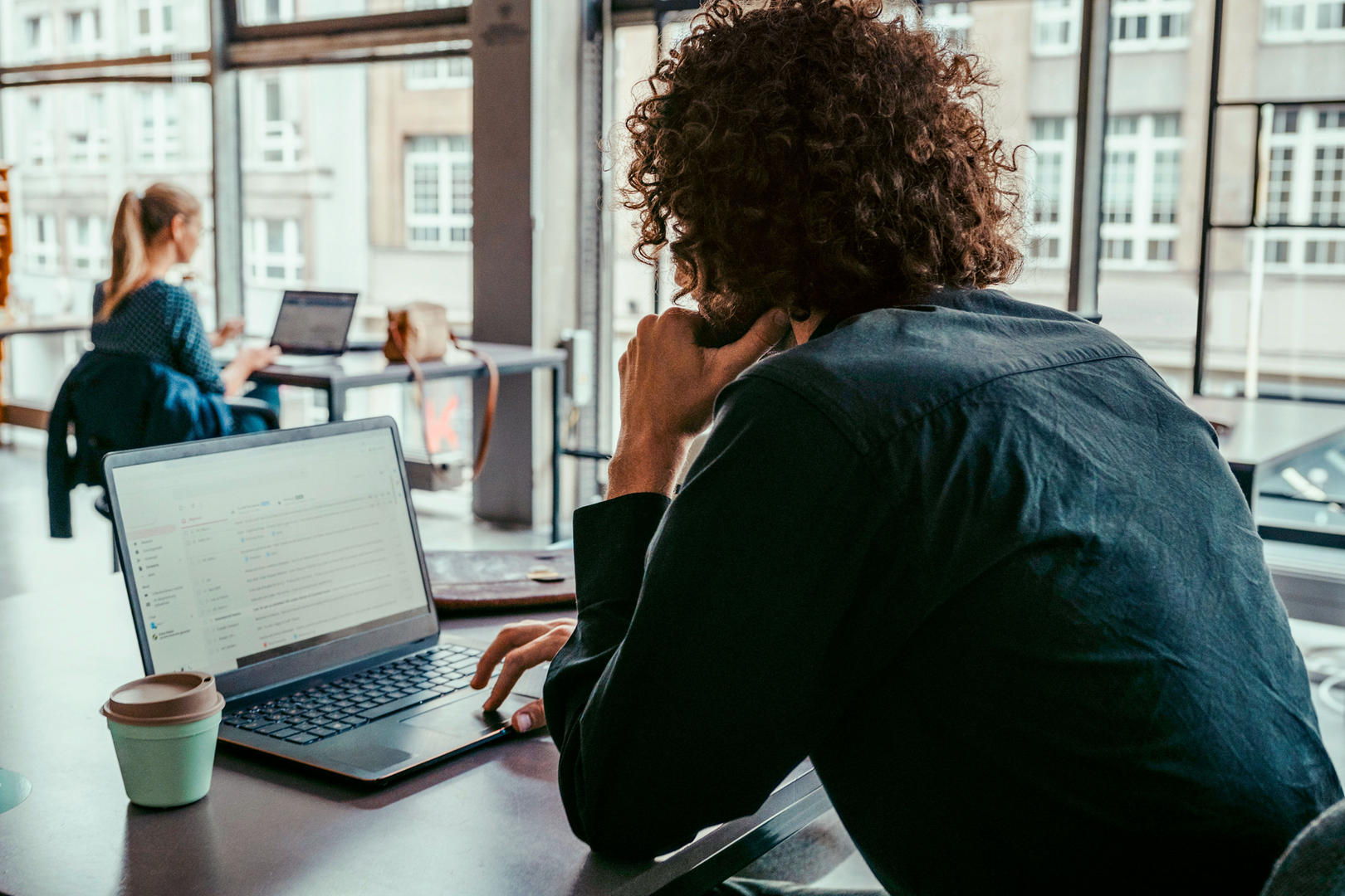 Mensch sitzt am Laptop und arbeitet