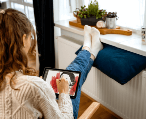 Die Heizungssteuerung im Mesh-Netzwerk sorgt für hohen Komfort während eine junge Frau auf einem Tablet zeichnet