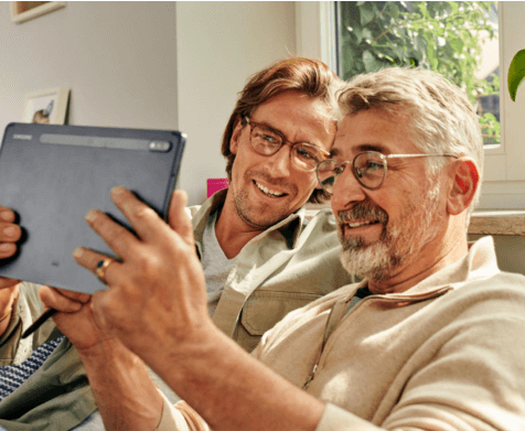 Zwei Männer verwenden eine App auf dem Tablet für die Rollladensteuerung im Mesh-Netzwerk