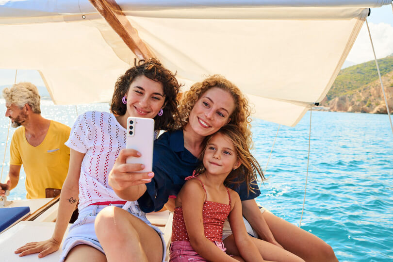 Eine Familie ist unterwegs auf einem Boot und führt ein Videotelefonat mit MagentaMobil