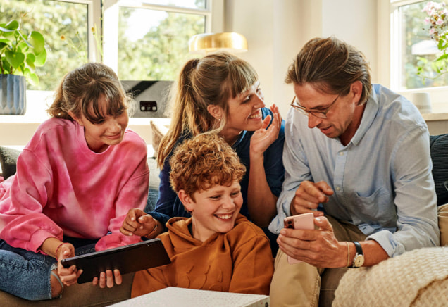 Familie mit Tablet und Smartphone prüft, welcher DSL-Anschluss am besten zu ihnen passt